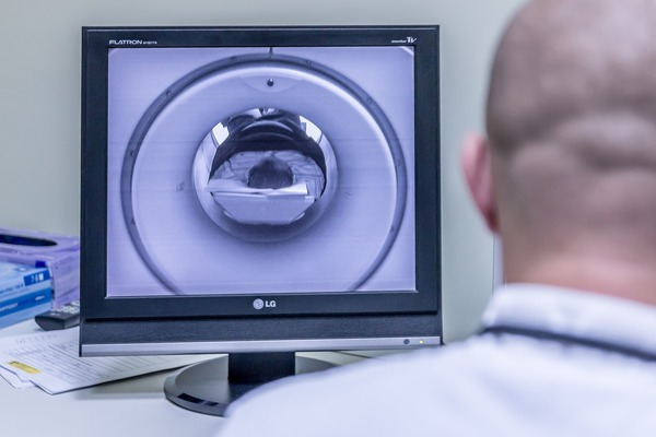 a radiologist observing a pathway glioma patient during MRI examination